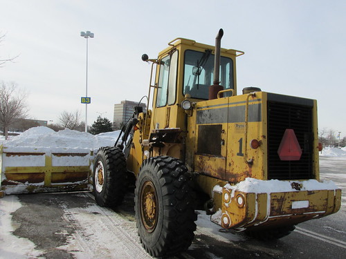 A front end loader tractor equipped with an extra wide snowplow attatchment.  Schaumburg Illinois.  Wednsday, January 8th, 2014. by Eddie from Chicago