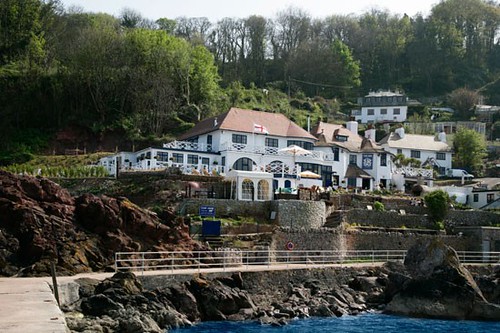 The white-washed buildins of the Cary Arms tucked into the cliffside