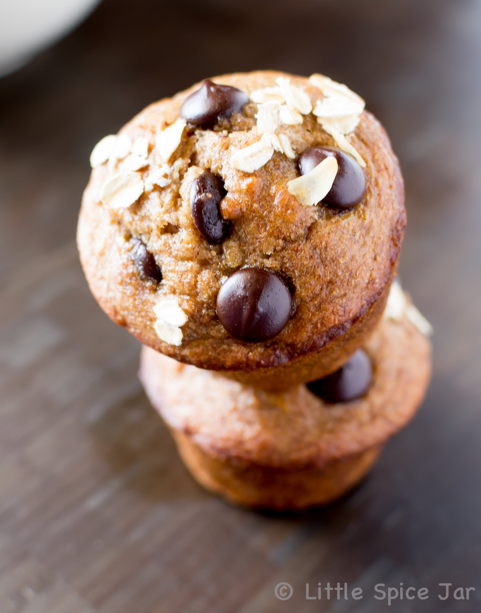 stack of two chocolate chip banana muffins showing oats and chips