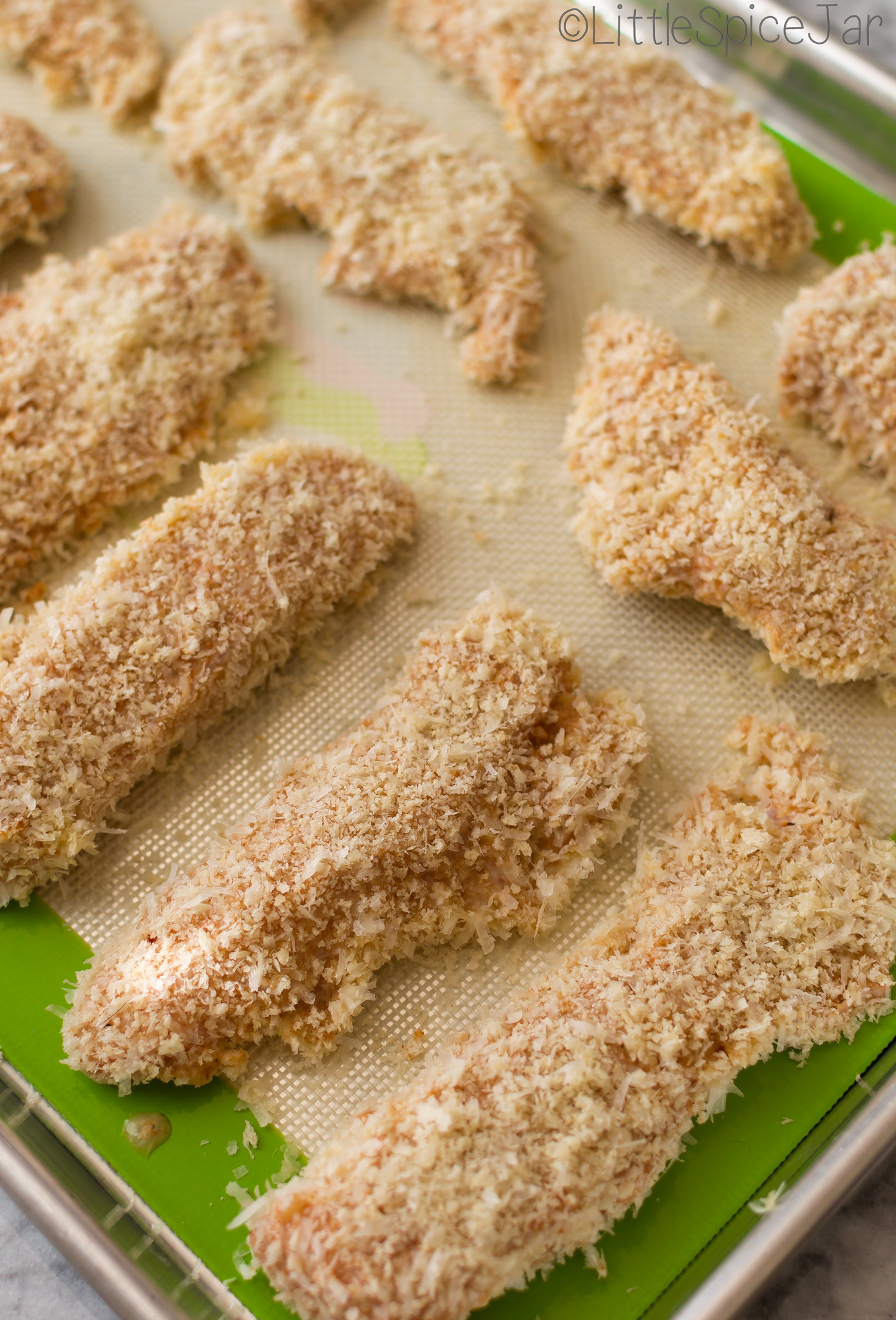 chicken fingers dredged in Panko coating on sheet pan lined with silicone baking pad