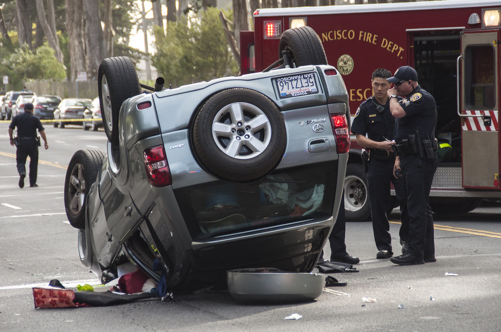 SFPD officers investigate the scene after a driver blacked out and flipped their car on Lake Merced Boulevard between Font Boulevard and Higuera Street around 2:30 p.m. Thursday, March 6. Photo by Jessica Christian / Xpress