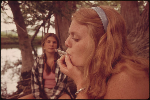 One Girl Smokes Pot While Her Friend Watches During an Outing in Cedar Woods near Leakey, Texas.