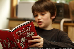 one little boy reading "ten little zombies" 