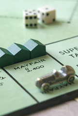 A British Monopoly board with three houses on Mayfair.