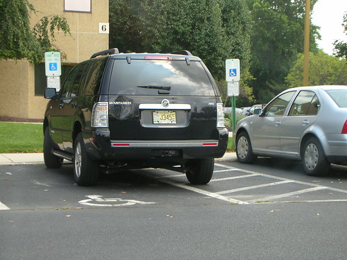 Car parked in a disabled spot, covering access aisle