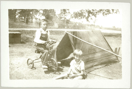 Two children, tent and tricycle