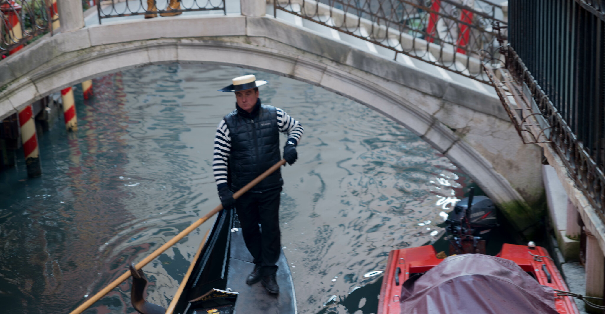 Gondolier rowing his gondola down a canal in Venice italy