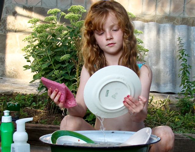 red-haired little girl washing dishes
