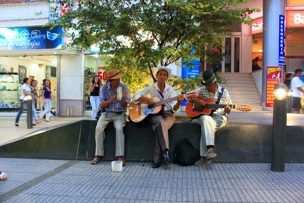 3 señores tocando guitarra en las calles