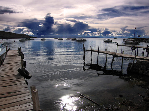 sun lake titicaca water clouds boats piers bolivia copocobana