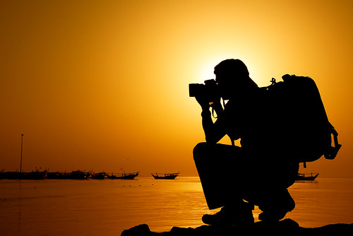 Backpacker taking a photo in sunset.