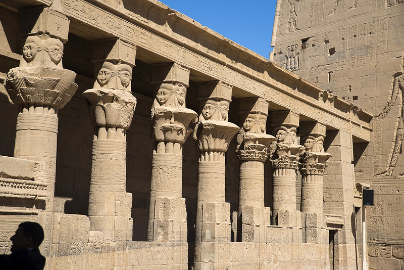 Temple at Philae: A colonnade surrounds three sides of the birth-house, with floral column capitals surmounted by sistrum capitals with Hathor heads.