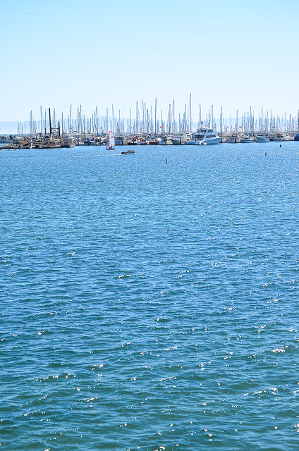 The ocean and boats in the harbor.