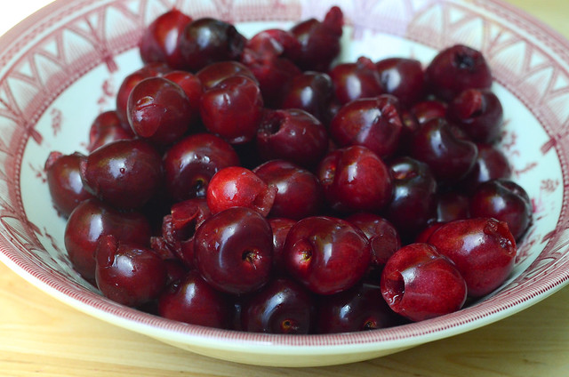 A bowl full of cherries with their pits removed.