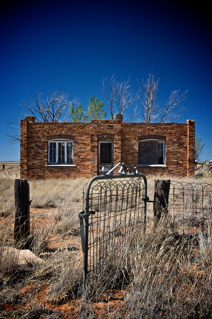Rustic abandoned brick house in the southwest with bright blue skies, photography art, for home and office décor. Title is: 138