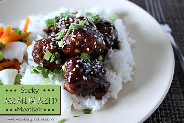 Sticky Asian Glazed Meatballs over a bed of rice on a white plate with a fork.