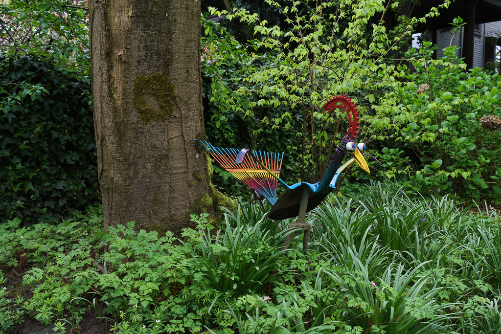 A colorful sculpture of a bird in a garden