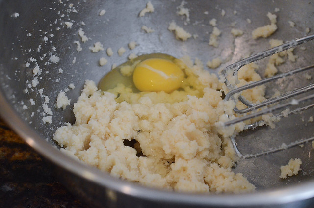 Butter and an egg in a bowl with beaters.