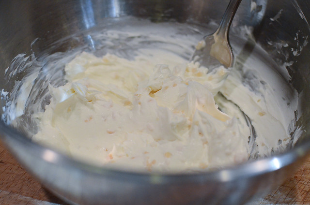 Softened cream cheese in a mixing bowl with a fork.