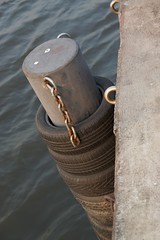 Recycling old tires as fenders on a bollard at Asiatique - The riverfront by the Chao Phraya river in Bangkok, Thailand