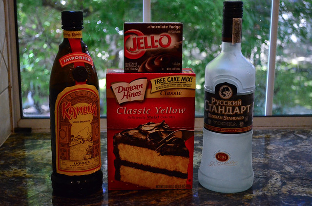 Two bottles of alcohol next to a box of cake mix and jell-o