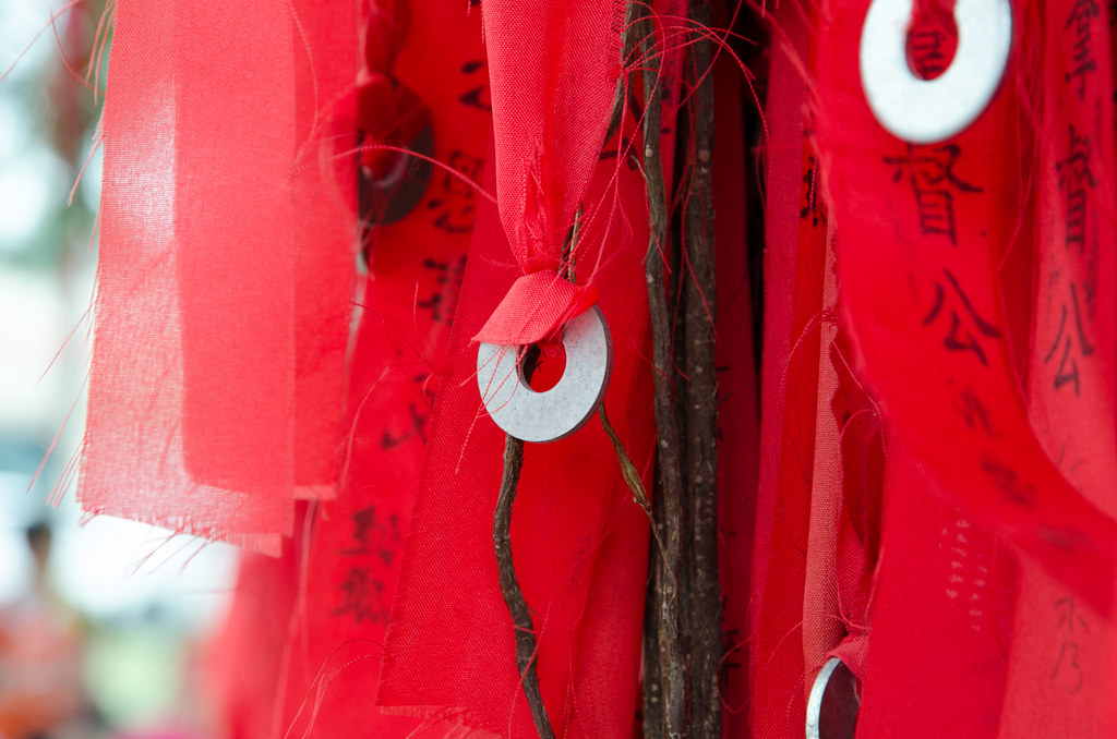 Red ribbon knotted with coin on the wishing tree
