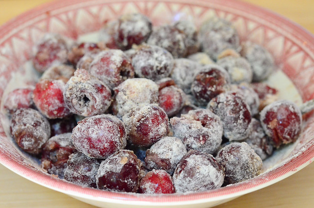 The bowl of cherries have been evenly coated with the mixture.