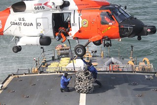 Petty Officer 3rd Class Kyle Kohl and Petty Officer 3rd Class Sean Liston, crew members of Coast Guard Cutter Seneca's tie down team, finish hooking up gear during a Vertical Replenishment exercise with a MH-60 Jayhawk from Air Station Elizabeth City. Coast Guard photo by Petty Officer 3rd Class Nicole Lockhart