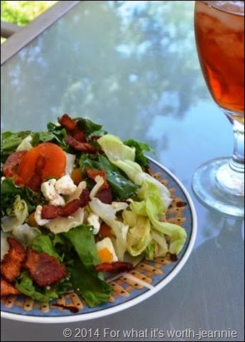 Apricot Feta Bacon Summer Salad in a bowl with a glass of tea.
