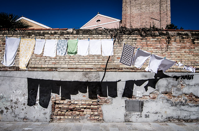 Laundry casts dark shadows in the bright sunlight on the island of Burano.
