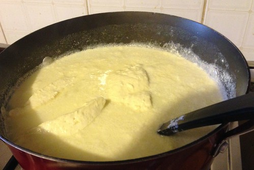 lifting hot wedges of cheese out of pot