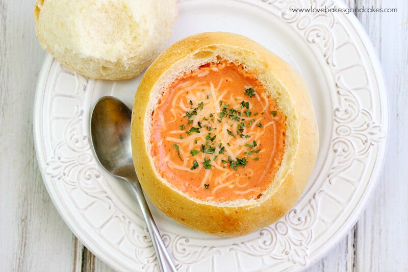 Easy Cooking with Slow Cooker Creamy Italian Parmesan Tomato Soup bowl on a white plate with a spoon looking from the top down.