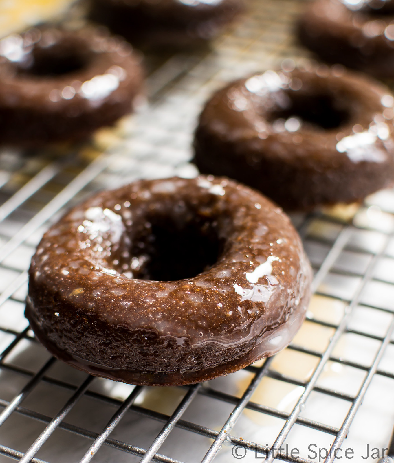 baked chocolate glazed donut on wire cooling rack