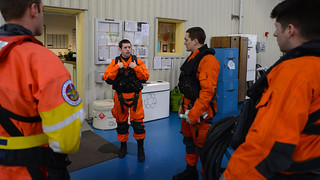 Lt. Cmdr. Vince Jansen, pilot (center right), discusses the upcoming medevac mission with his crew Lt. Bill Burwell, co-pilot (right), Petty Officer 3rd Class Zach Hamilton, flight mechanic (center left), and Petty Officer 3rd class Eli Bell, rescue swimmer (far left) at Air Station Kodiak, Alaska, April 21, 2014. In addition to the regular crew a Coast Guard flight surgeon and a hospital corpsman from the Rockmore King Clinic in Kodiak attended the flight to provide inflight medical care to three injured crewmen from the 587-foot cargo vessel Copacabana. U.S. Coast Guard photo by Chief Petty Officer Sara Mooers. 