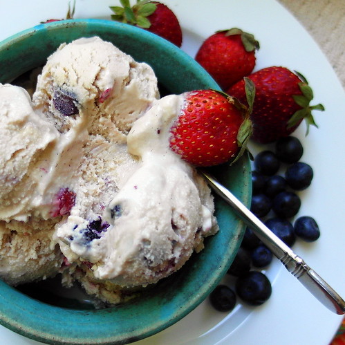 Fruit Dip Ice Cream in a bowl. The fruit is seen mixed in the ice cream. Whole berries are on the side.