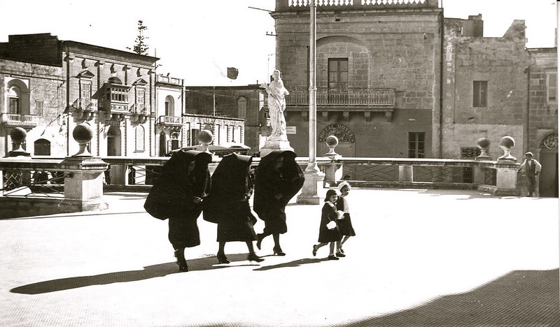 Three faldetta wearing women and two little girls head to church on Malta in 1935.