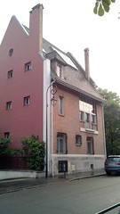 Au coin de la rue, un immeuble brique et rouge