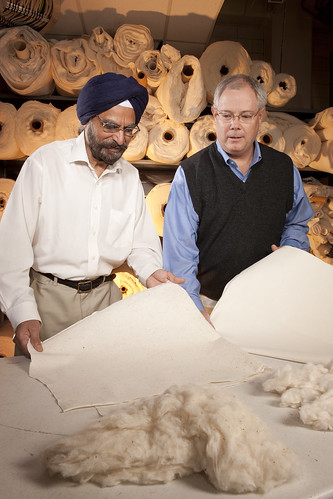ARS cotton technologist Paul Sawhney (left) and research leader Brian Condon examine needled-punched nonwoven products made with classical raw cotton and precleaned raw cotton, respectively.