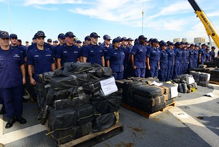 The crew of U.S. Coast Guard Cutter Boutwell stands at attention among pallets of seized cocaine during an award ceremony aboard the Boutwell at Naval Base San Diego, Oct. 6, 2014. The Boutwell returned from a 90-day counter drug patrol in which they made six drug interdictions. (U.S. Coast Guard photo by Petty Officer 2nd Class Connie Terrell)